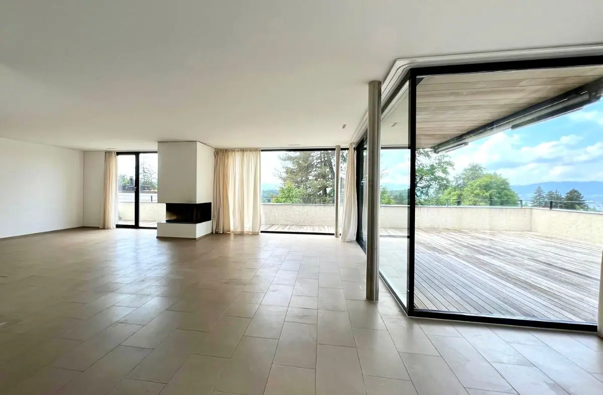 Penthouse in Küsnacht ZH: Wohnraum mit Cheminée und Zugang zur Holzterrasse